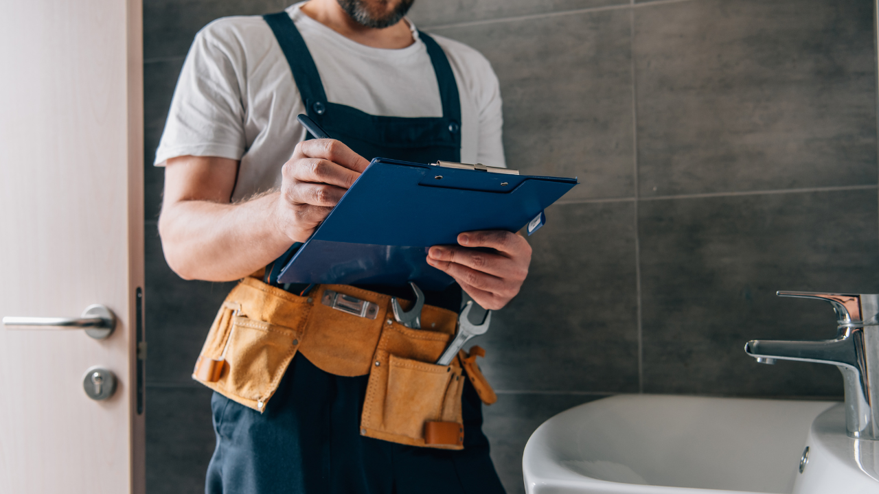 plumber with clipboard looking at how much to charge
