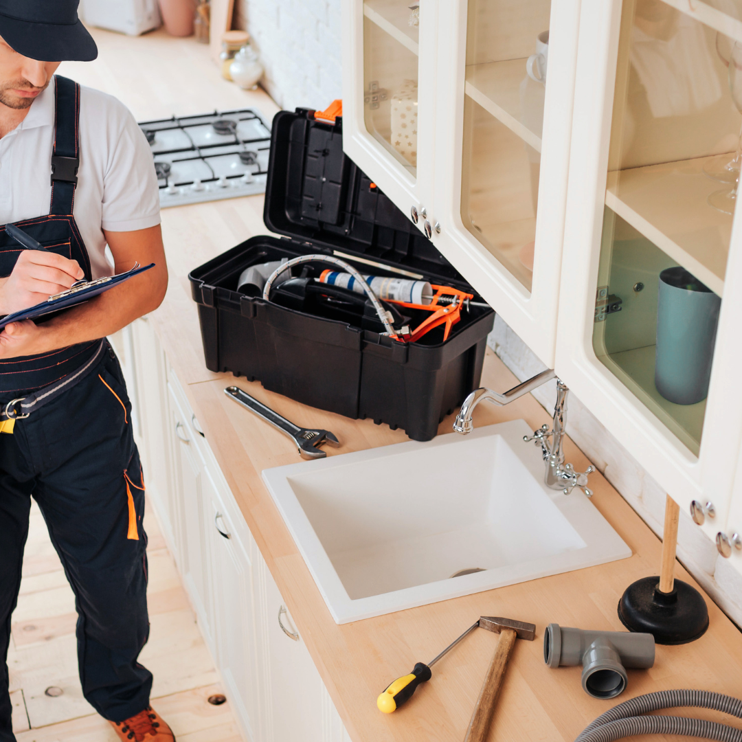 emergency plumber taking notes with toolbox on worktop